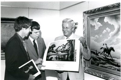 From left, the museum’s director Dick Leet, Jerry Caralstadt and Art Brandeberry, who is holding “Spring Tryout” by Thomas Hart Benton, in 1982. Photo courtesy of the Charles H. MacNider Art Museum